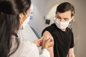 2 people one receiving a vaccine